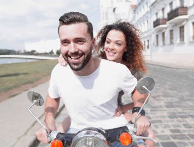Mutlu çift sürme vintage scooter açık havada.