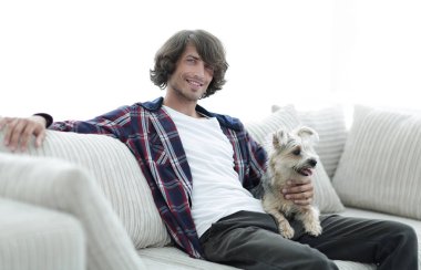 şık adam köpeğiyle kanepede oturan.