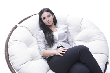 Yuvarlak, yumuşak bir sandalyede oturan modern genç kadın.
