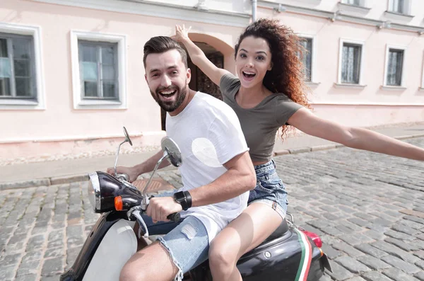 Vrolijke jonge paar rijden een scooter en plezier — Stockfoto