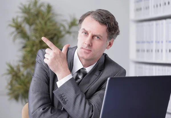 Primer plano. hombre de negocios confiado apuntando al espacio de copia . —  Fotos de Stock