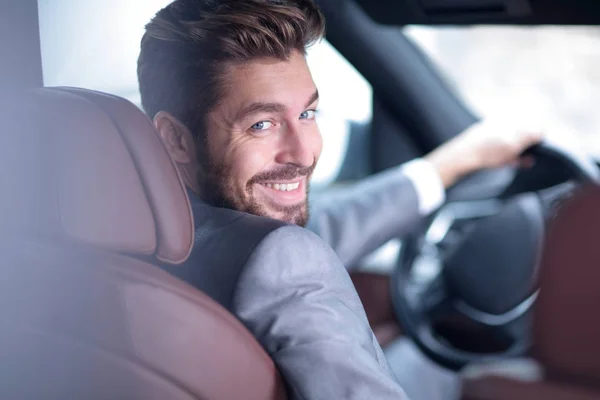 Successful man sitting behind the wheel of a prestigious car — Stock Photo, Image