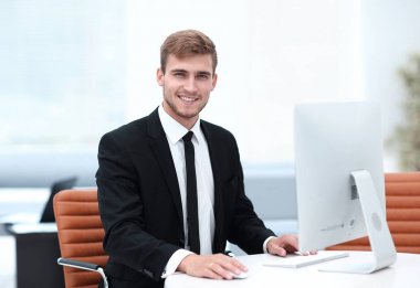 Kendine güvenen iş adamı masasında oturuyor..