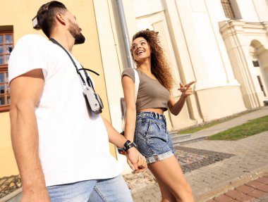 Bir çift şehrin sokaklarında yürüyor ve eğleniyor.