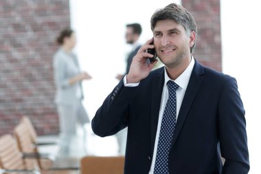 Kendine güvenen iş adamı telefonda konuşuyor..