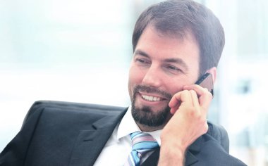 Telefonda konuşan genç bir iş adamının portresi.