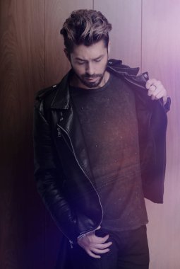 Ahşap duvara yaslanmış yakışıklı bir adamın portresi..