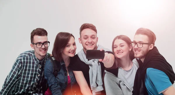 Група молодих людей, сидячи на лавці, посміхається і відправляє — стокове фото