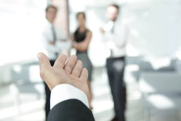 background image of businessman holding out hand for a handshake.
