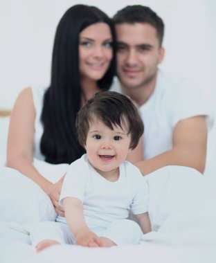 Küçük çocuklu bir aile yatak odasında yatıyor.