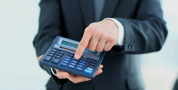 Empresario utiliza una calculadora para los cálculos —  Fotos de Stock