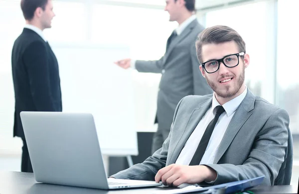 Porträt eines gutaussehenden jungen Geschäftsmannes mit Menschen im Hintergrund bei einem Bürotreffen — Stockfoto