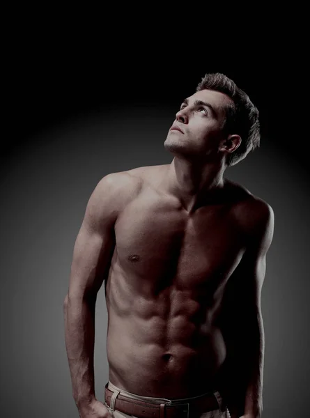 Молода чоловіча модель позує свої м'язи — стокове фото