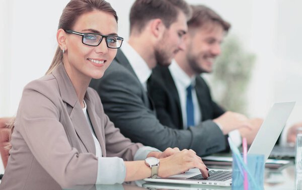 Portrait of happy business woman with  colleagues interacting on