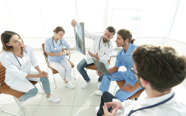 radiologists and a surgeon discussing a radiograph of a patient