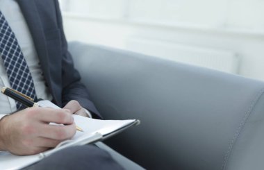 İşadamı bir sözleşme imzalar. Elinde kalem tutan.