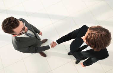 İki iş adamı ofiste el sıkışıyor.