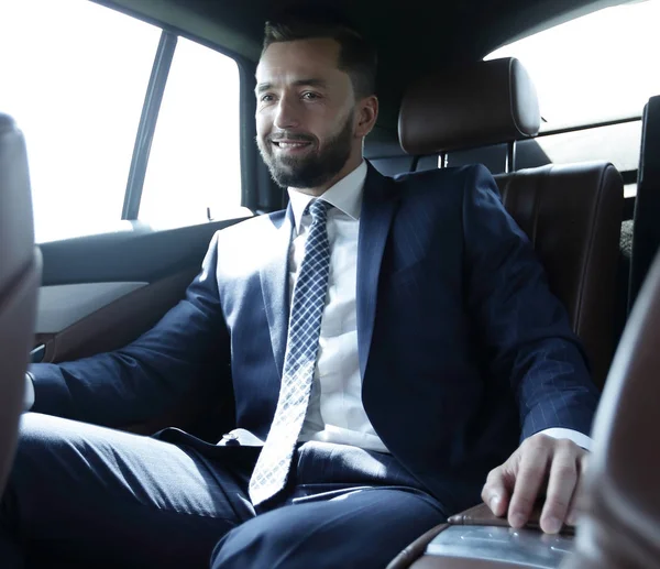 Geschäftsmann sitzt auf dem Rücksitz eines Autos — Stockfoto