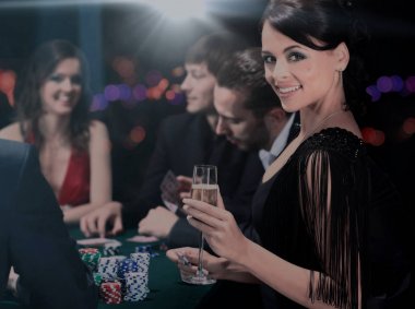 bir kumarhanede bir masa etrafında oturup poker oyuncuları