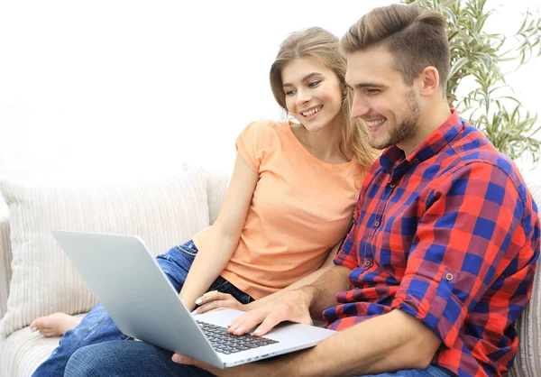 Usmíval se mladý pár s notebookem sedět na gauči — Stock fotografie
