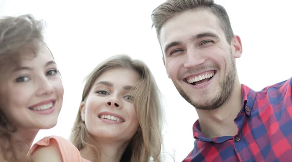 Close-up de três jovens sorrindo em fundo branco — Fotografia de Stock