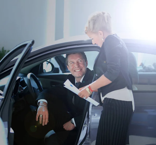 Uomo comprare una macchina in concessionaria seduto nella sua nuova auto — Foto Stock