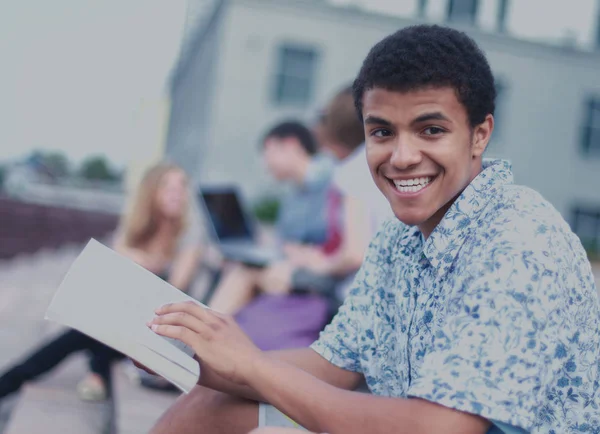 Jonge jongen zitten met vrienden — Stockfoto