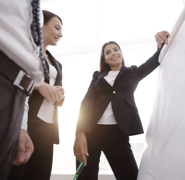 Geschäftsfrau zeigt mit Filzstift auf Flipchart — Stockfoto