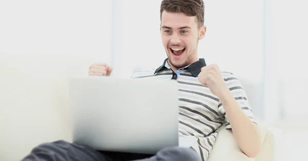 Homem relaxante no sofá com computador portátil — Fotografia de Stock