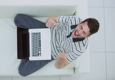 Mutlu genç adam, onun dizüstü bilgisayar kullanarak yakın çekim.