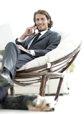 onun evinde sandalyede oturan smartphone cep telefonu ile konuşurken işadamı