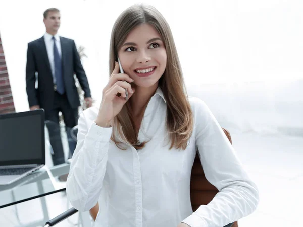 Close seup.female assistant talking on mobile phone in office — стоковое фото