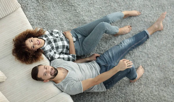 Por encima de los recién casados acostados en la alfombra en un nuevo apartamento — Foto de Stock