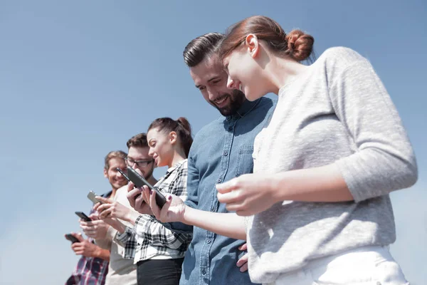 Jóvenes que utilizan teléfonos inteligentes para buscar en la red — Foto de Stock