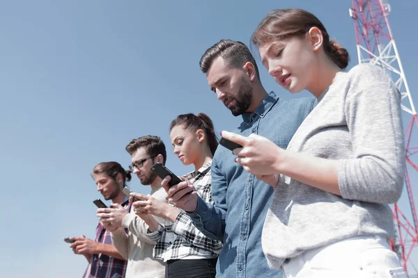 Jóvenes que utilizan teléfonos inteligentes para buscar en la red — Foto de Stock