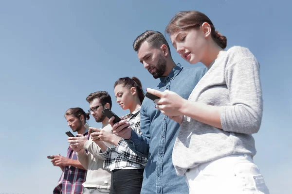 Junge Leute nutzen Smartphones zur Netzwerkdurchsuchung — Stockfoto