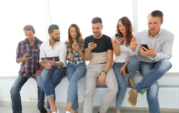 Young people in casual clothes using gadgets — Stock Photo, Image