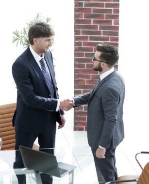 İki işadamı ofiste el sıkışıyor.