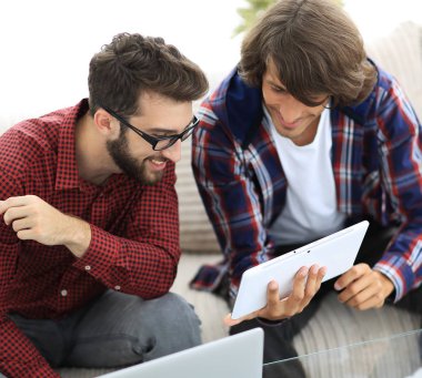iki creative web tasarımcıları bir tablet ve bir dizüstü bilgisayar ile çalışma.
