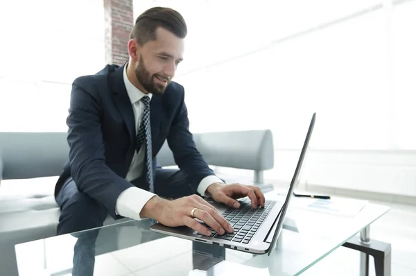 Homme qui travaille avec succès sur un ordinateur portable dans un bureau moderne — Photo