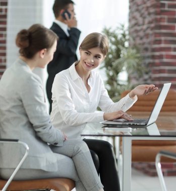 Yöneticisi ve istemci laptop ile alınan bilgi tartışıyorlar