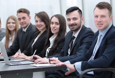 İş ekibi konferans odasındaki masada oturuyor.