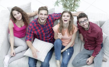 dört mutlu arkadaş kanepede otururken gülüyor