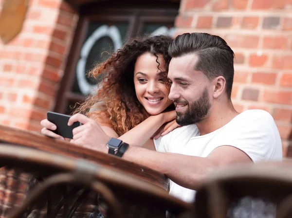 Happy αγάπη ζευγάρι χρησιμοποιώντας ένα smartphone που κάθεται στην βεράντα — Φωτογραφία Αρχείου