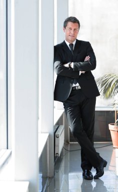 ofis koridorunda duran ciddi iş adamı.
