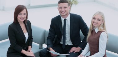 Modern ofiste masanın etrafında çalışan iş adamları.