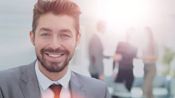 Hombre de negocios guapo en una oficina con fondo borroso — Foto de Stock