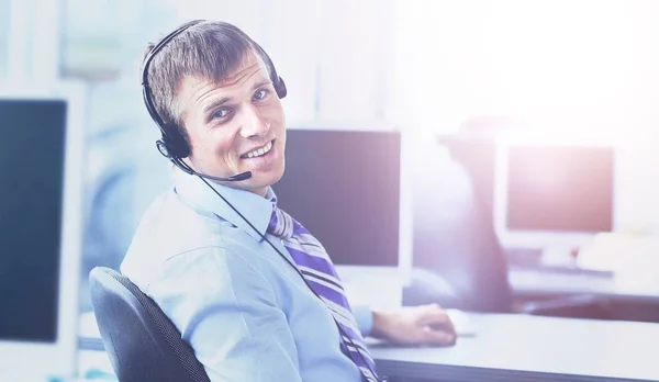 Jovem feliz trabalhando no call center, usando fone de ouvido — Fotografia de Stock