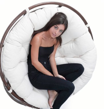 Yukarıdan görüntüleyin. yuvarlak bir rahat sandalyede oturan genç kadın.