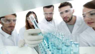arka plan görüntüsü sıvı cam tüp içinde eğitim microbiologists oluşan bir gruptur.